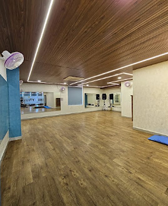 Empty activity hall with wooden floor, slat ceiling and mirror wall